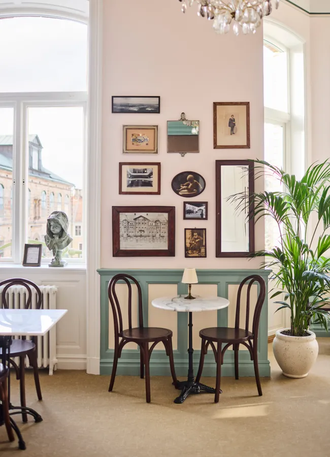 Bland andra motiv, speglar och gamla bilder hänger en gammal biljett på väggen. 